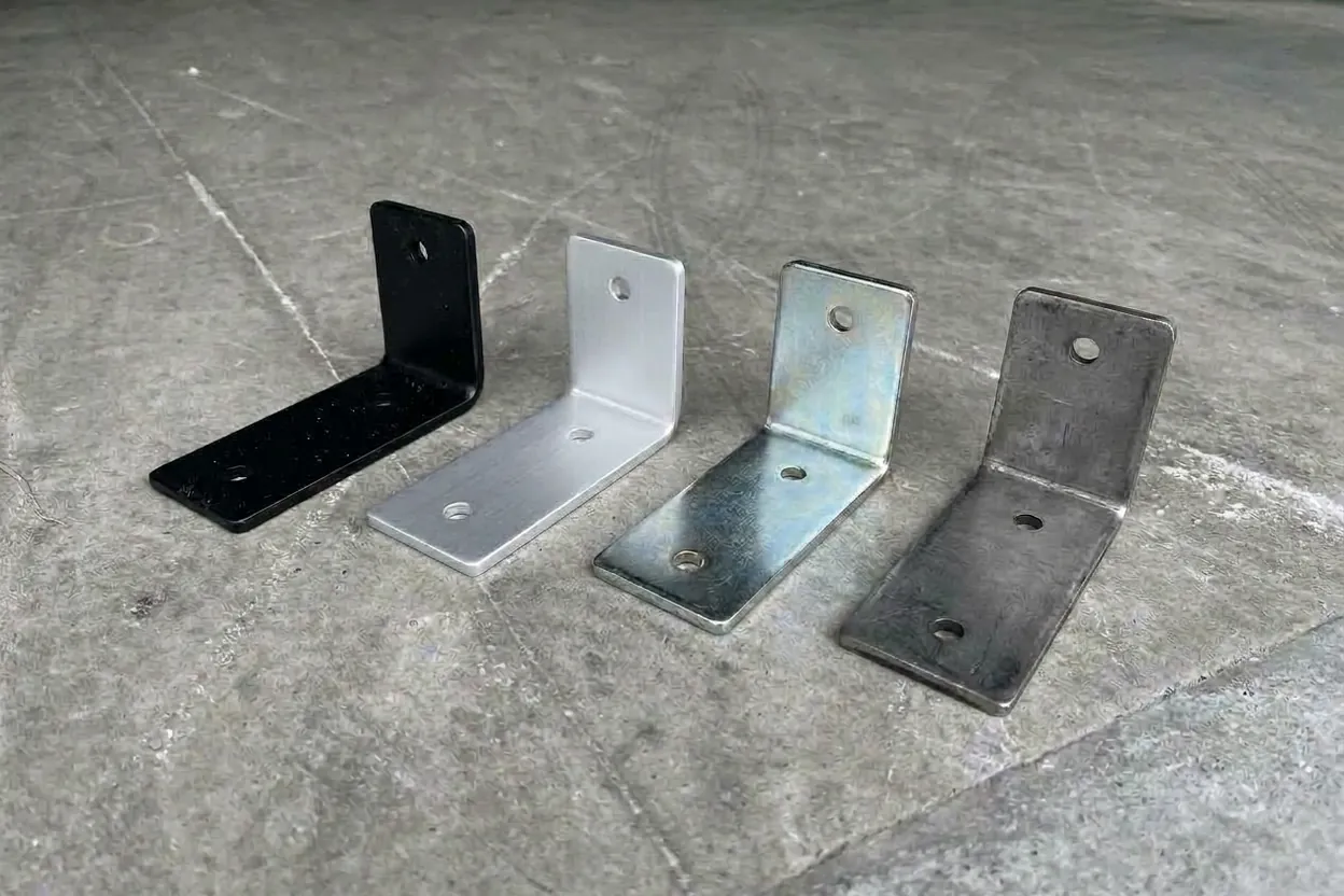 The same L-bracket in four finishes: black powder coat, anodised aluminium, zinc plate and raw steel