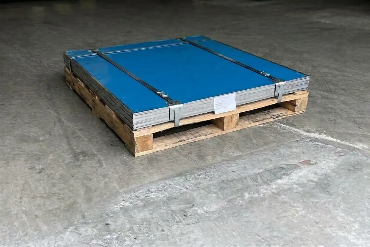 A strapped bundle of new 304 stainless sheets on a pallet, the mill's label on its edge