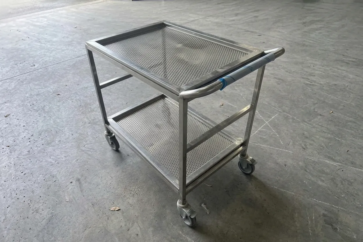 A stainless trolley: laser-perforated, folded shelves on a welded frame